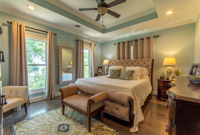 Bedroom featuring crown molding, dark hardwood / wood-style floors, ceiling fan, and a raised ceiling