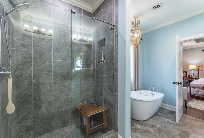 Bathroom featuring a shower with shower door, tile patterned floors, and crown molding