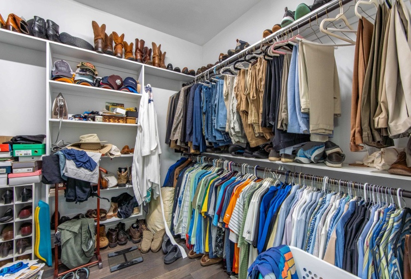 Walk in closet with hardwood / wood-style floors