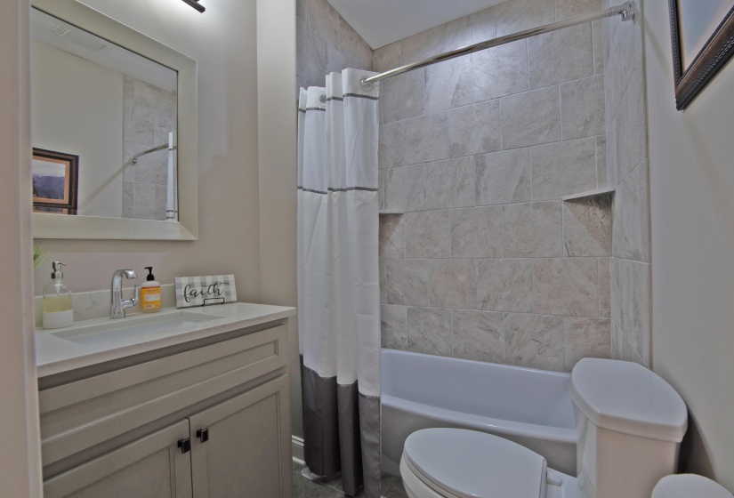 Full bathroom featuring shower / bath combo with shower curtain, toilet, and vanity