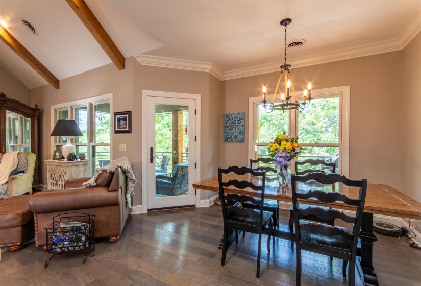 Dining area featuring plenty of natural light, dark hardwood / wood-style flooring, a notable chandelier, and vaulted ceiling with beams
