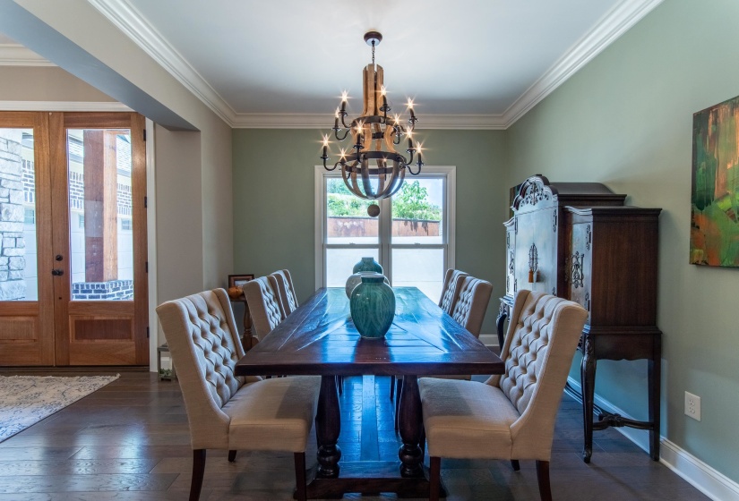 Dining room with an inviting chandelier, crown molding, french doors, and dark hardwood / wood-style flooring
