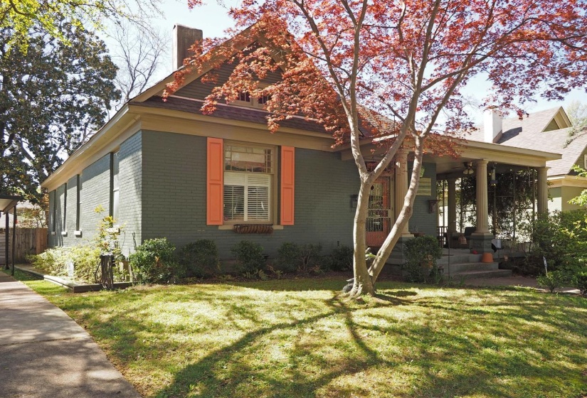 View of front facade featuring brick siding, a front lawn, and a chimney