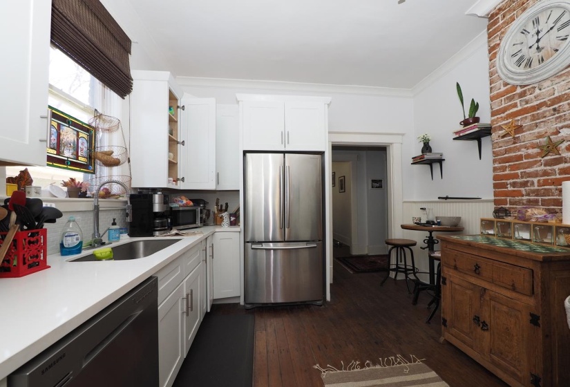 Kitchen featuring open shelves, stainless steel appliances, wainscoting, dark wood finished floors, and white cabinets