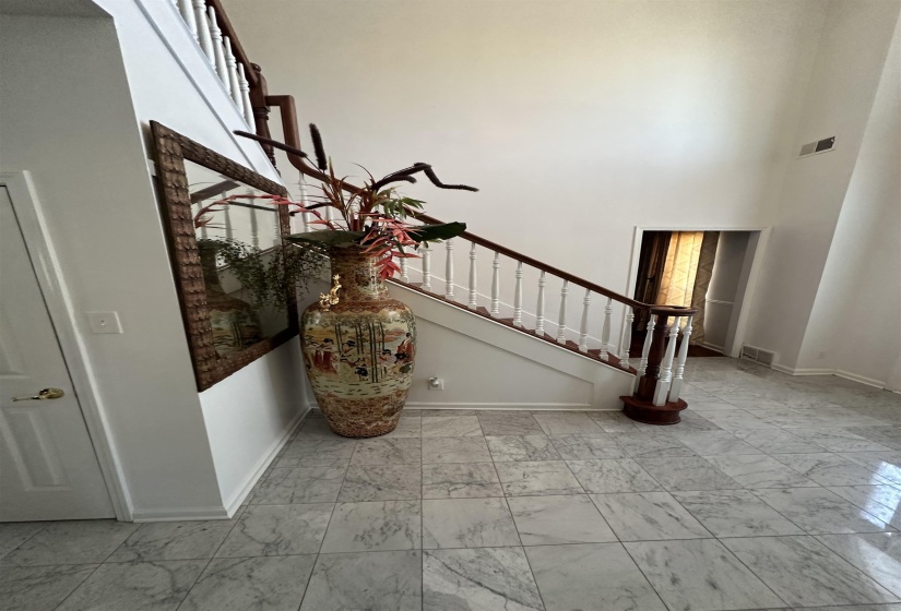 Stairway featuring marble finish floors and a high ceiling