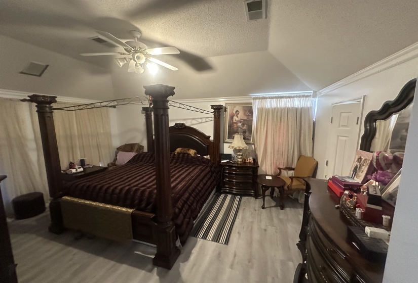 Bedroom featuring light wood finished floors, a ceiling fan, and ornamental molding