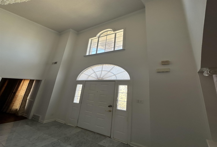 Entryway featuring a high ceiling and crown molding