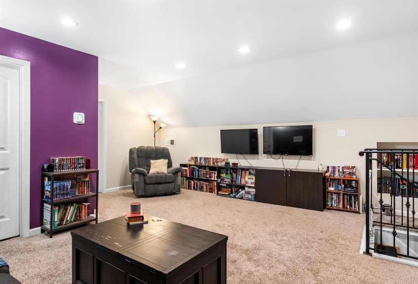 Carpeted living room featuring vaulted ceiling and recessed lighting