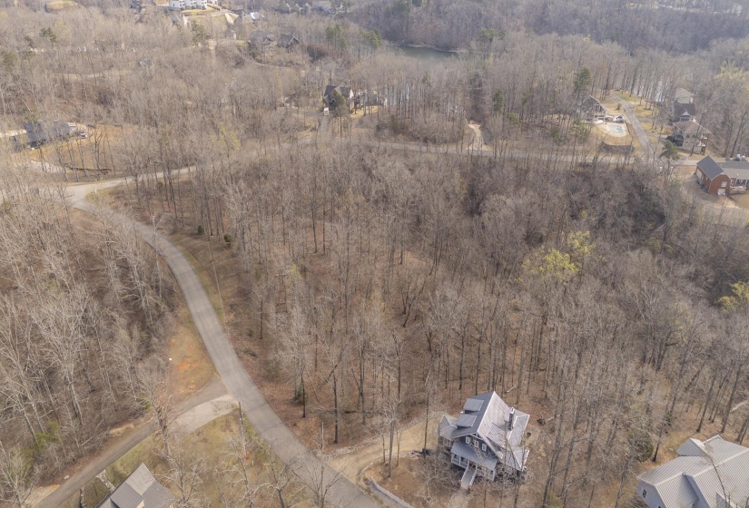 Aerial view of property and surrounding area featuring a forest