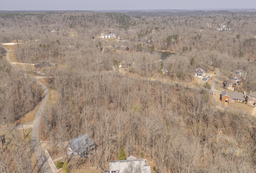 Aerial view of property's location with a heavily wooded area