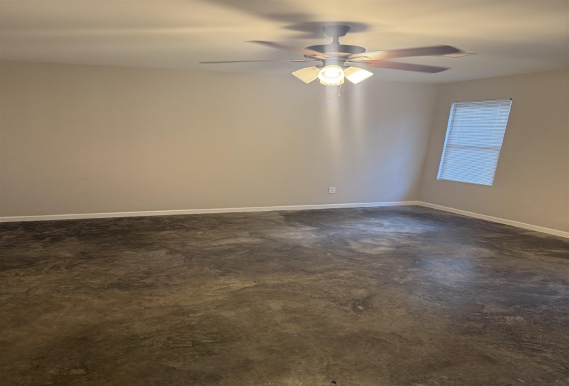 Unfurnished room featuring concrete floors and a ceiling fan