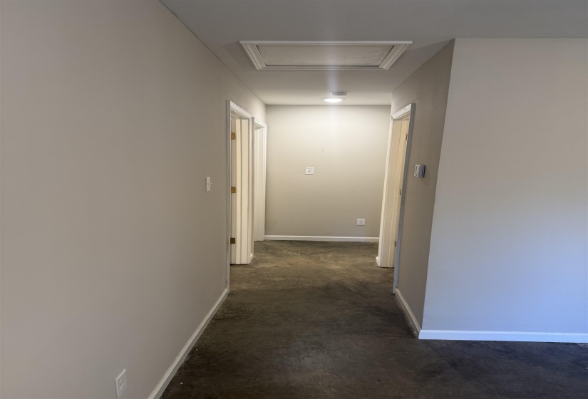 Hallway with baseboards and attic access