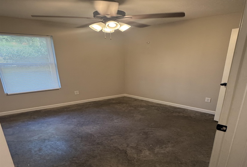 Spare room with ceiling fan and baseboards
