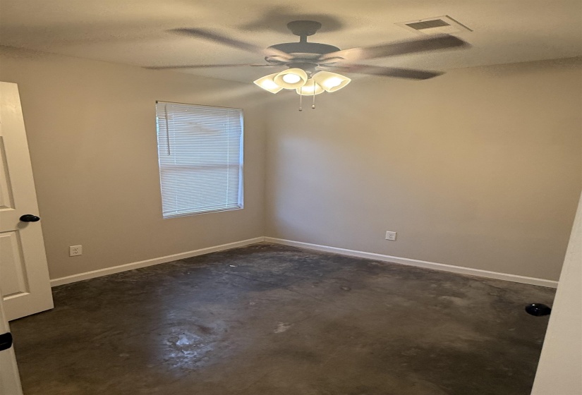 Spare room featuring concrete flooring and a ceiling fan
