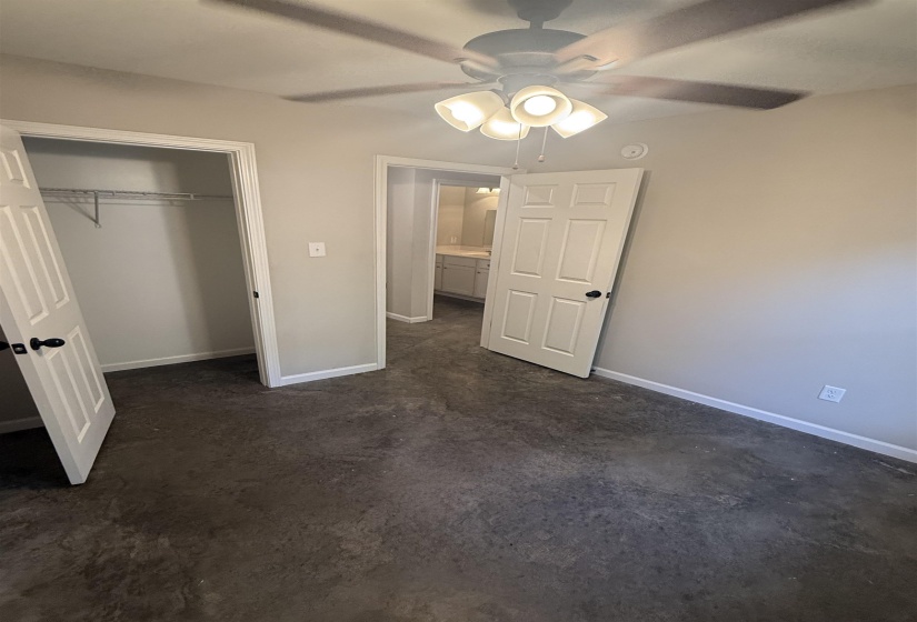 Unfurnished bedroom featuring concrete floors, a closet, and ceiling fan