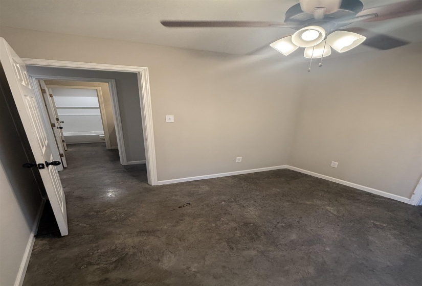 Empty room with concrete flooring and a ceiling fan