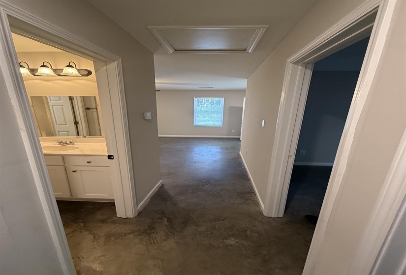 Hallway with concrete floors and attic access