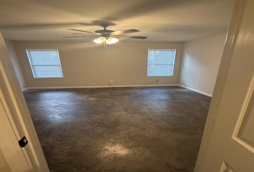 Spare room featuring concrete floors and a ceiling fan
