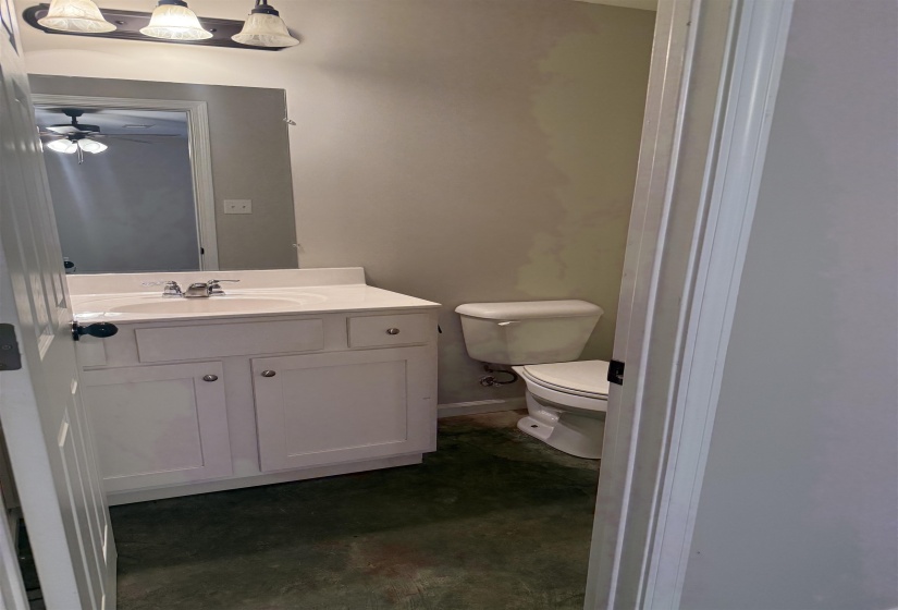 Half bath featuring vanity, concrete floors, and a ceiling fan