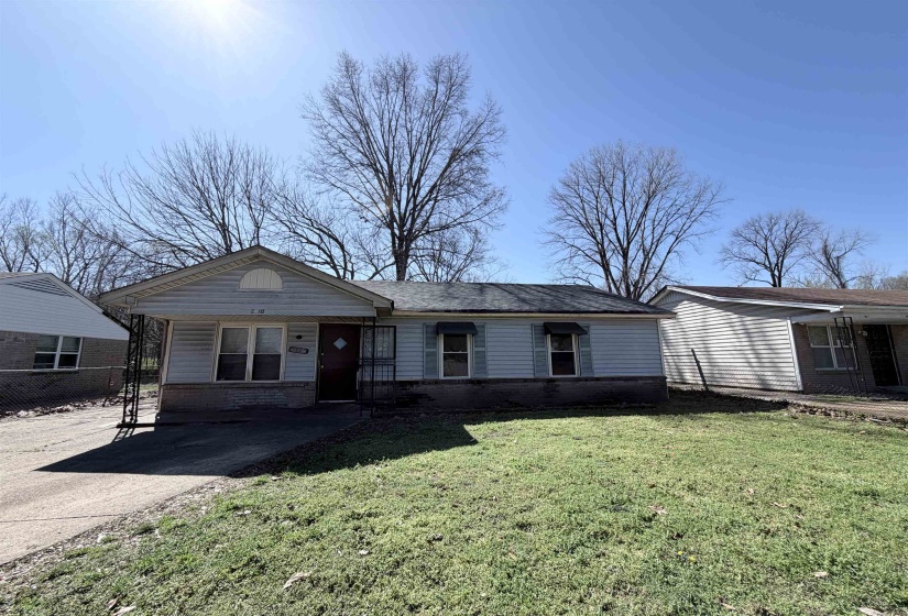 Ranch-style house with covered porch, a front lawn, and brick siding