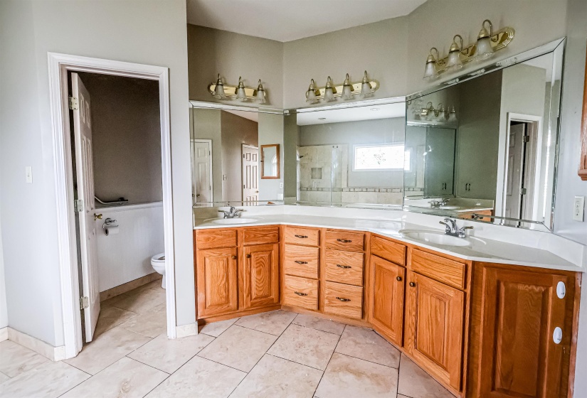 Full bathroom with toilet, a sink, tile patterned floors, and double vanity