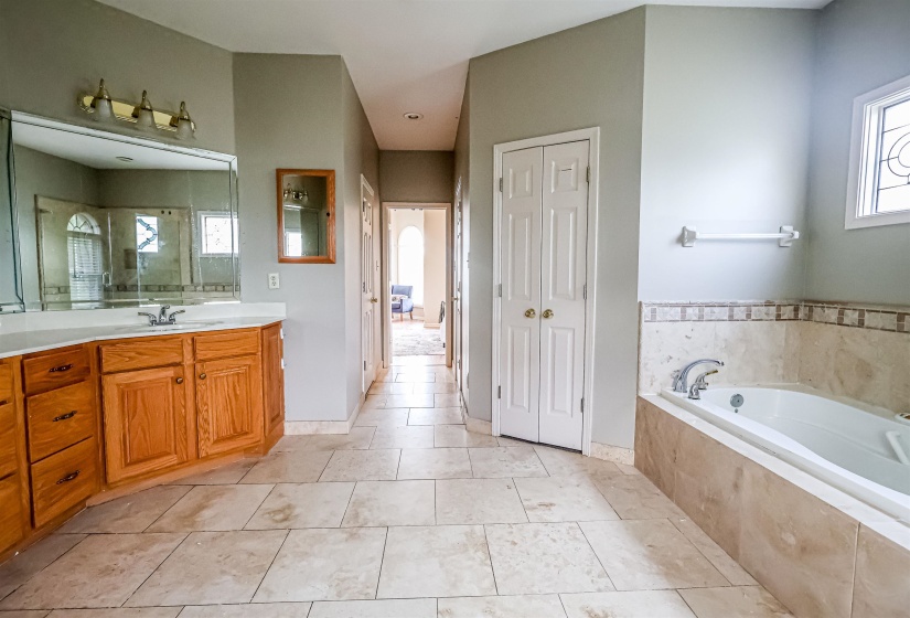 Bathroom with tile patterned flooring, vanity, a bath, and a walk in shower
