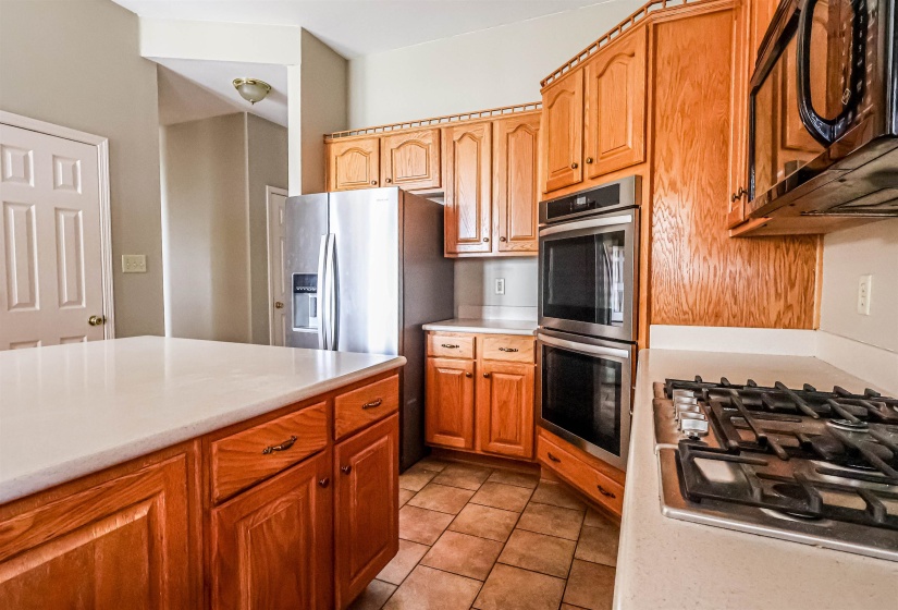 Kitchen with light countertops, light tile patterned floors, and stainless steel appliances