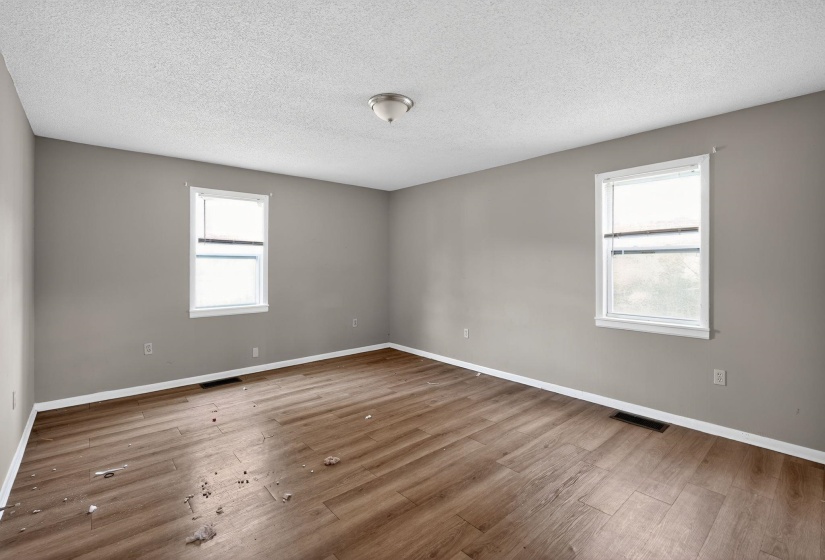 Spare room featuring plenty of natural light, a textured ceiling, and light wood-type flooring