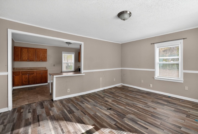 Spare room with ornamental molding, dark wood-type flooring, and a textured ceiling