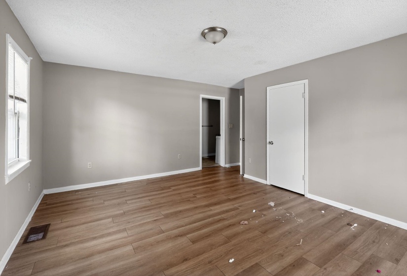 Unfurnished bedroom featuring a textured ceiling and wood finished floors