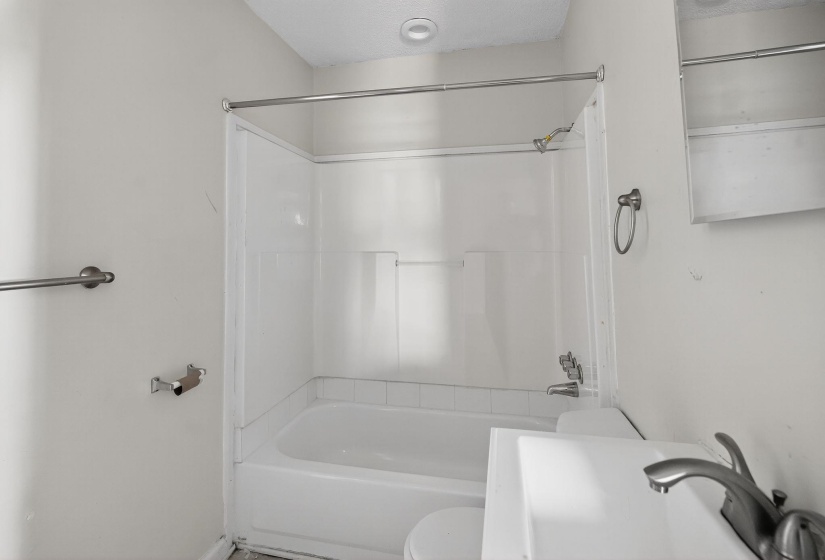 Full bathroom featuring bathtub / shower combination and a textured ceiling