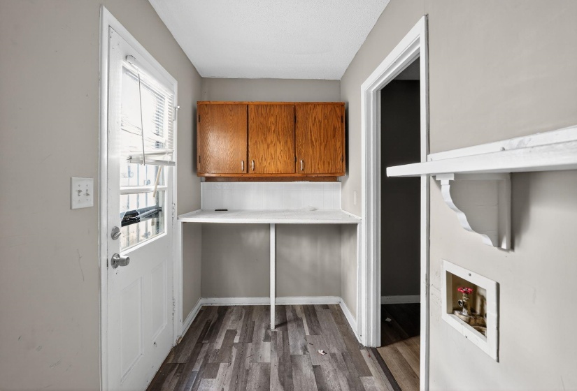 Laundry area featuring dark wood-style floors, washer hookup, and cabinet space