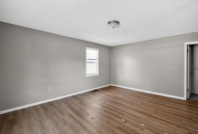 Spare room with wood finished floors and a textured ceiling