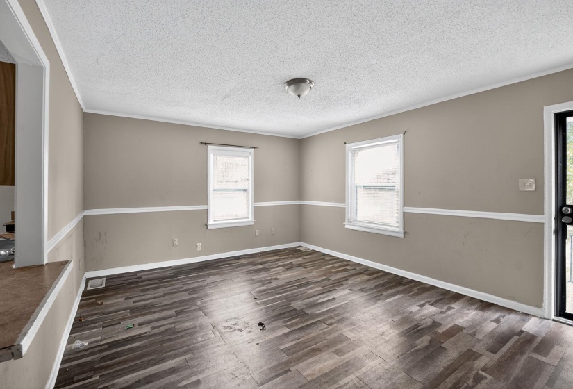 Spare room featuring dark wood finished floors, ornamental molding, and a textured ceiling