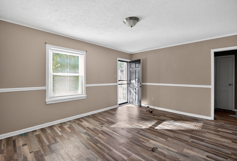 Spare room with ornamental molding, a textured ceiling, and wood finished floors