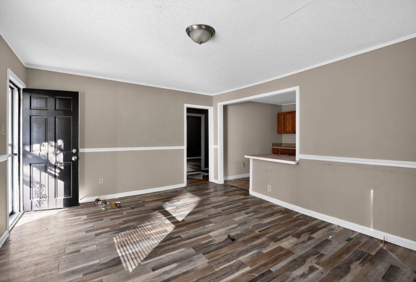 Spare room with crown molding, dark wood-style flooring, and a textured ceiling