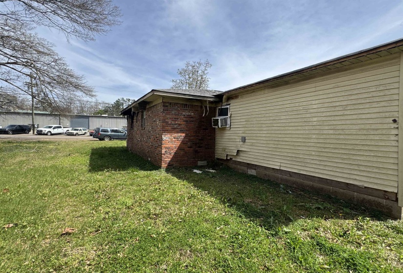 View of home's exterior featuring a yard, brick siding, and crawl space