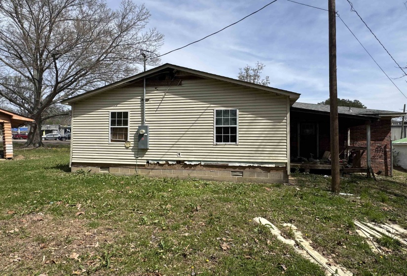 View of home's exterior with crawl space, a lawn, and a wooden deck