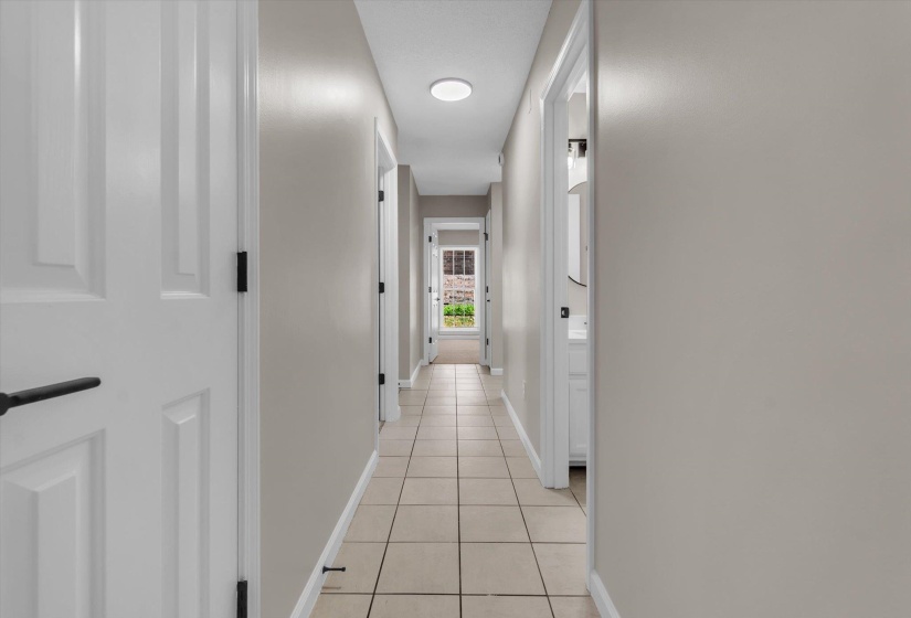 Hall featuring baseboards and light tile patterned flooring