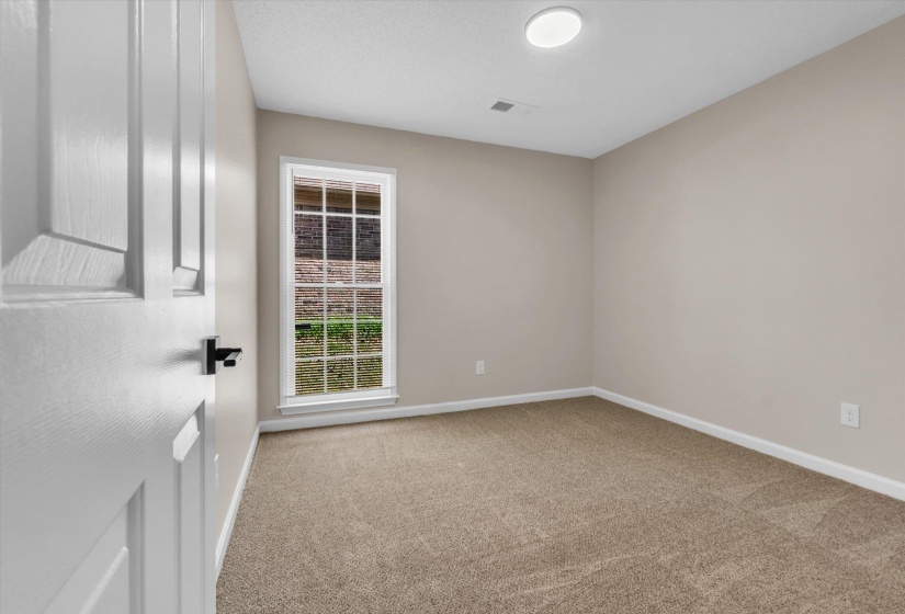 Empty room featuring baseboards and light carpet
