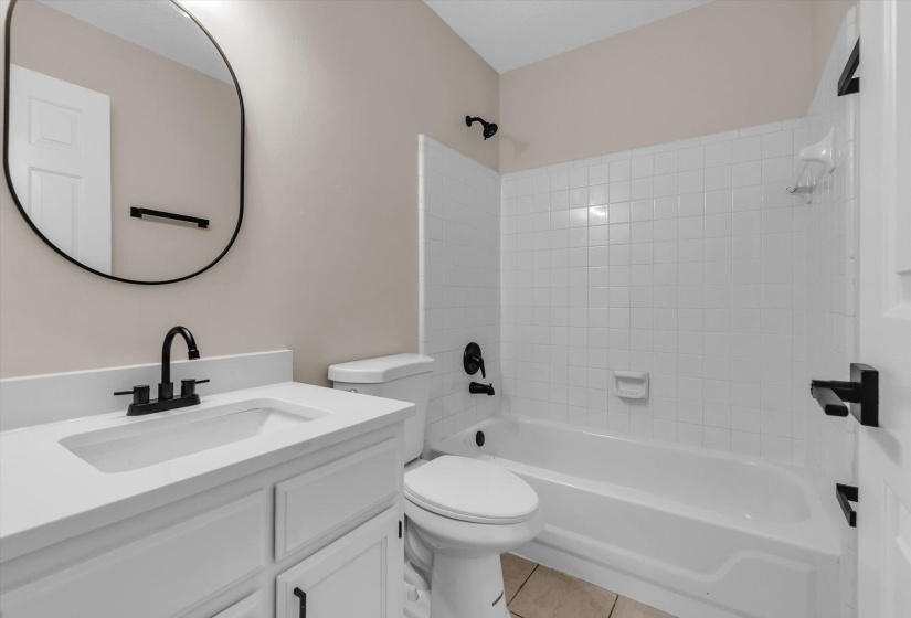 Full bath with vanity, bathing tub / shower combination, and light tile patterned flooring