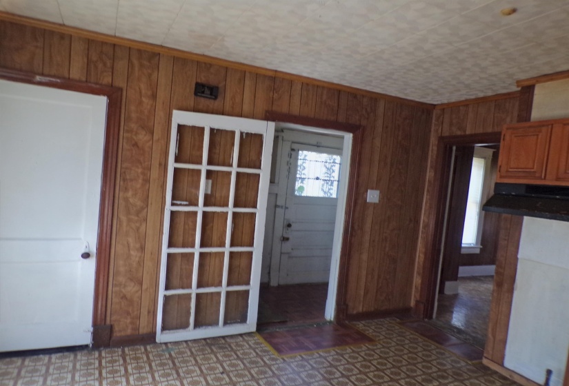 Foyer entrance with wood walls and dark floors