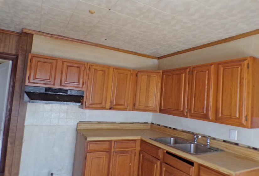 Kitchen featuring light countertops, wood finish cabinets, and crown molding