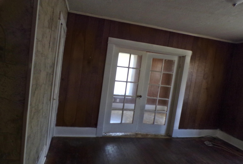 Entryway featuring french doors, wood finished floors, ornamental molding, and wood walls