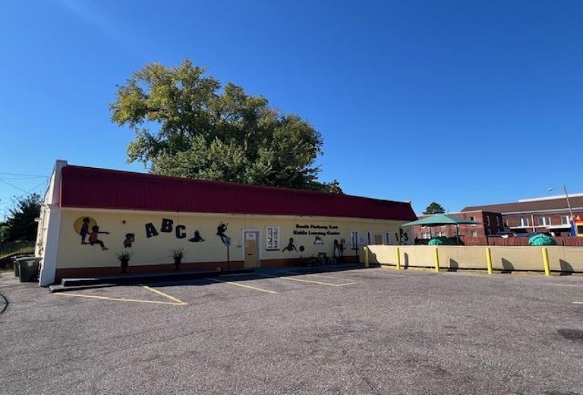 View of building exterior featuring uncovered parking