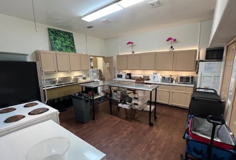 Kitchen with dark wood finished floors, appliances with stainless steel finishes, and light countertops