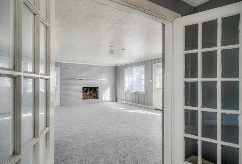 Unfurnished living room with carpet flooring, a fireplace, and ornamental molding