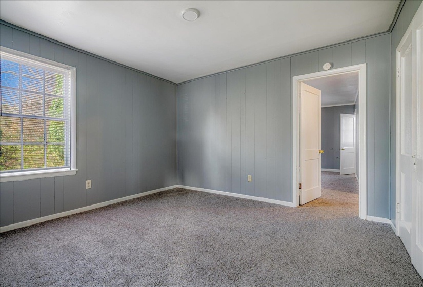 Spare room featuring light colored carpet and wooden walls