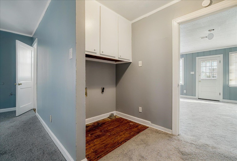 Laundry room with light colored carpet and crown molding