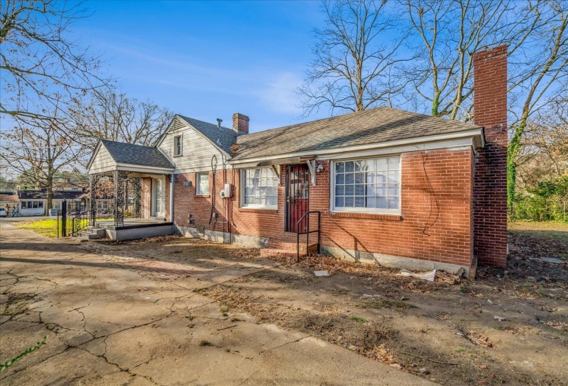 Bungalow featuring a chimney, brick siding, and a shingled roof